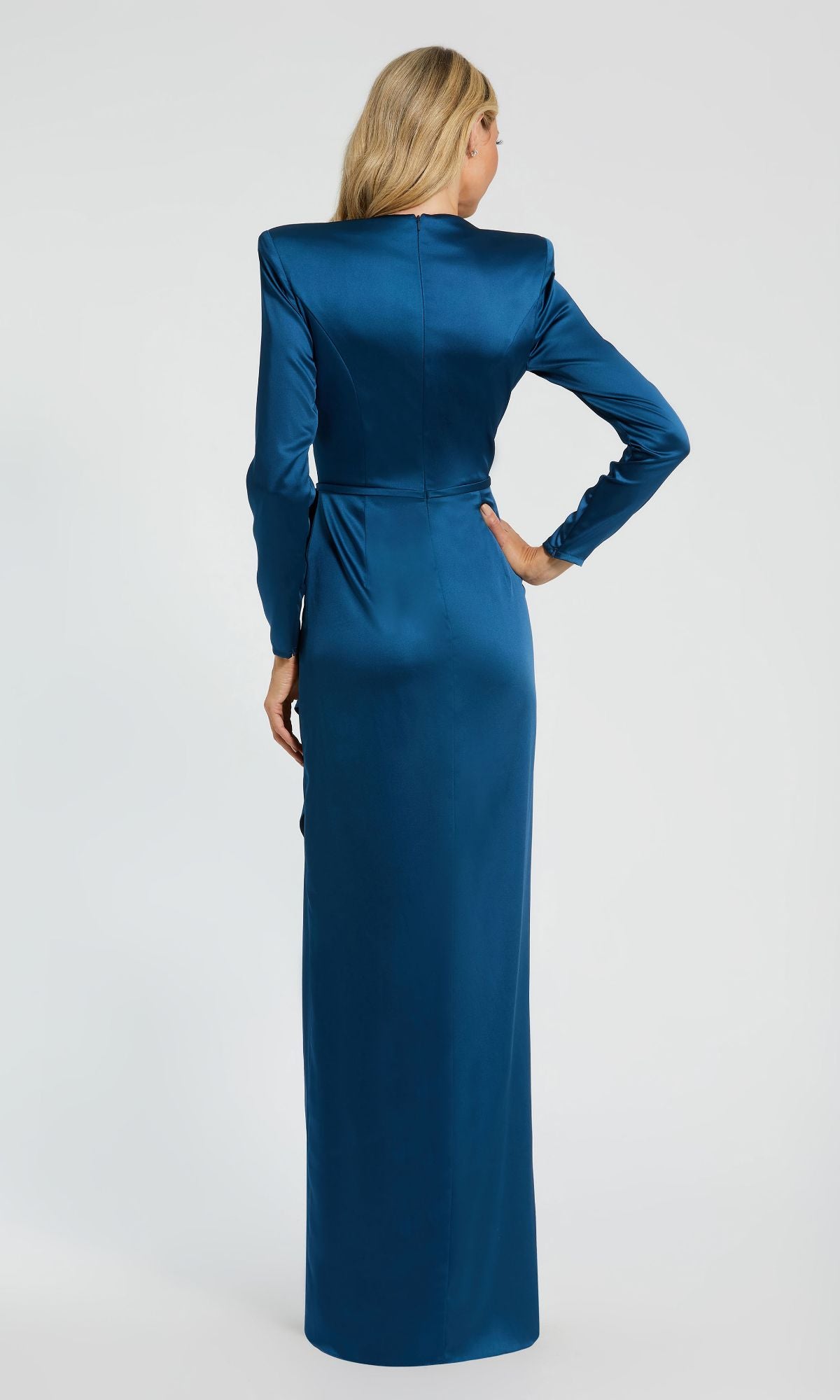 A woman stands with her back to the camera, showcasing the Bold-Shoulder Long Formal Dress: Mac Duggal 26676 in teal satin. The floor-length evening gown flows elegantly against a plain light background.